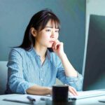 オフィスでパソコンを見ながら事業アイデアを考える女性経営者