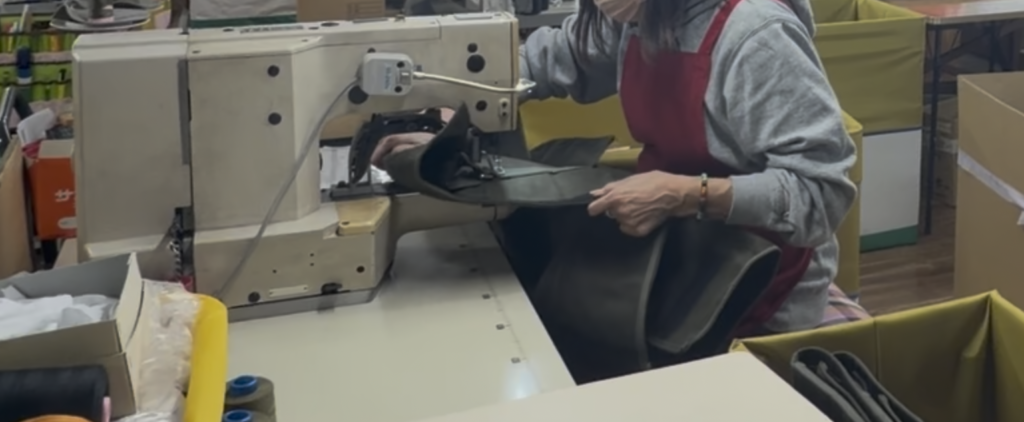 厚物素材のバッグを工業用ミシンで縫製する国内縫製工場の作業