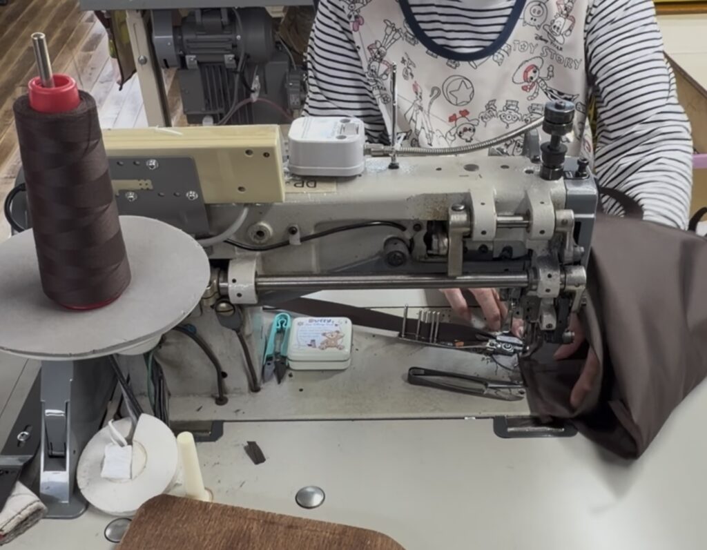 厚手素材のバッグパーツを縫製する工業用ミシンと縫製作業の様子