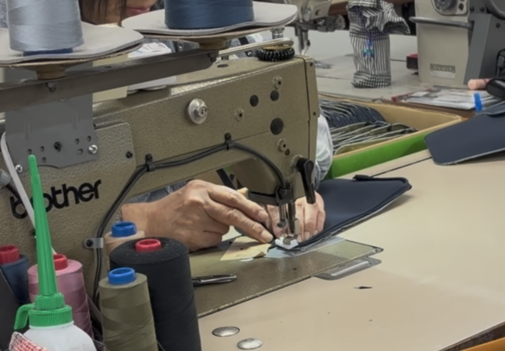 厚物縫製に対応する工業用ミシンで多層構造の素材を縫製している作業風景