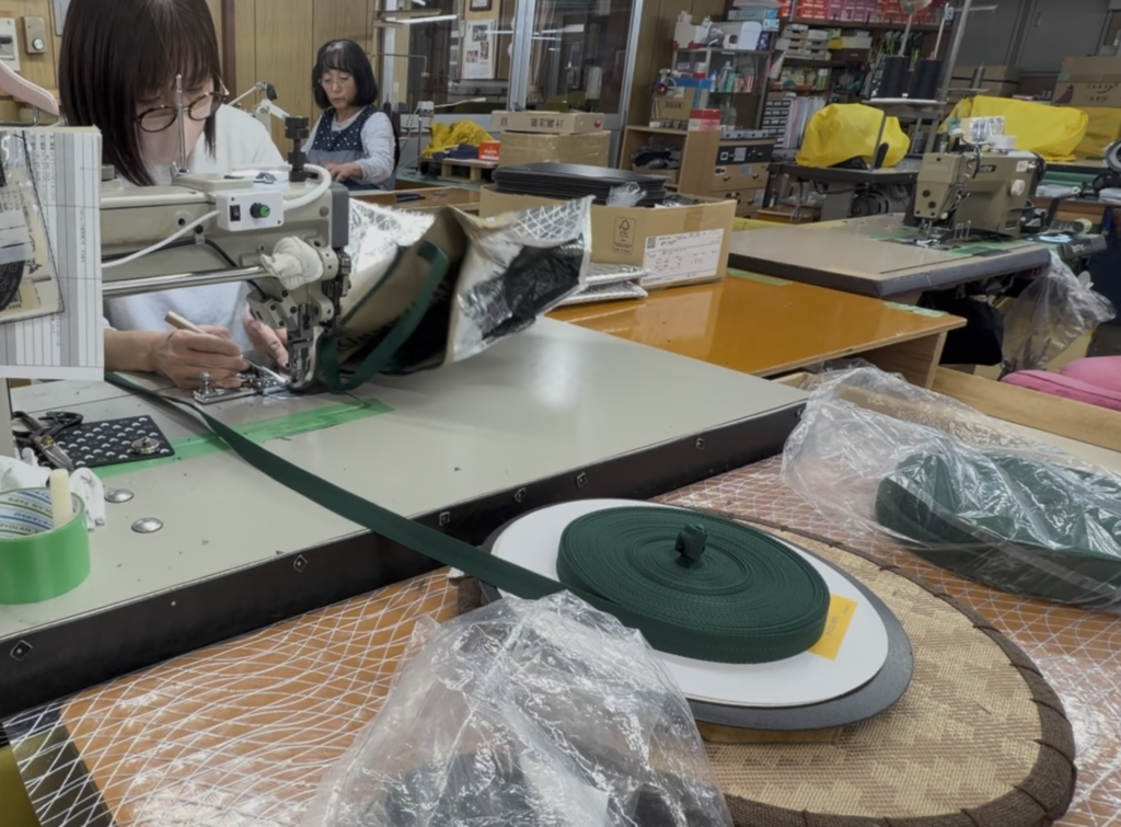 厚物縫製に対応した縫製工場で、テープと多層素材をミシン加工している作業風景
