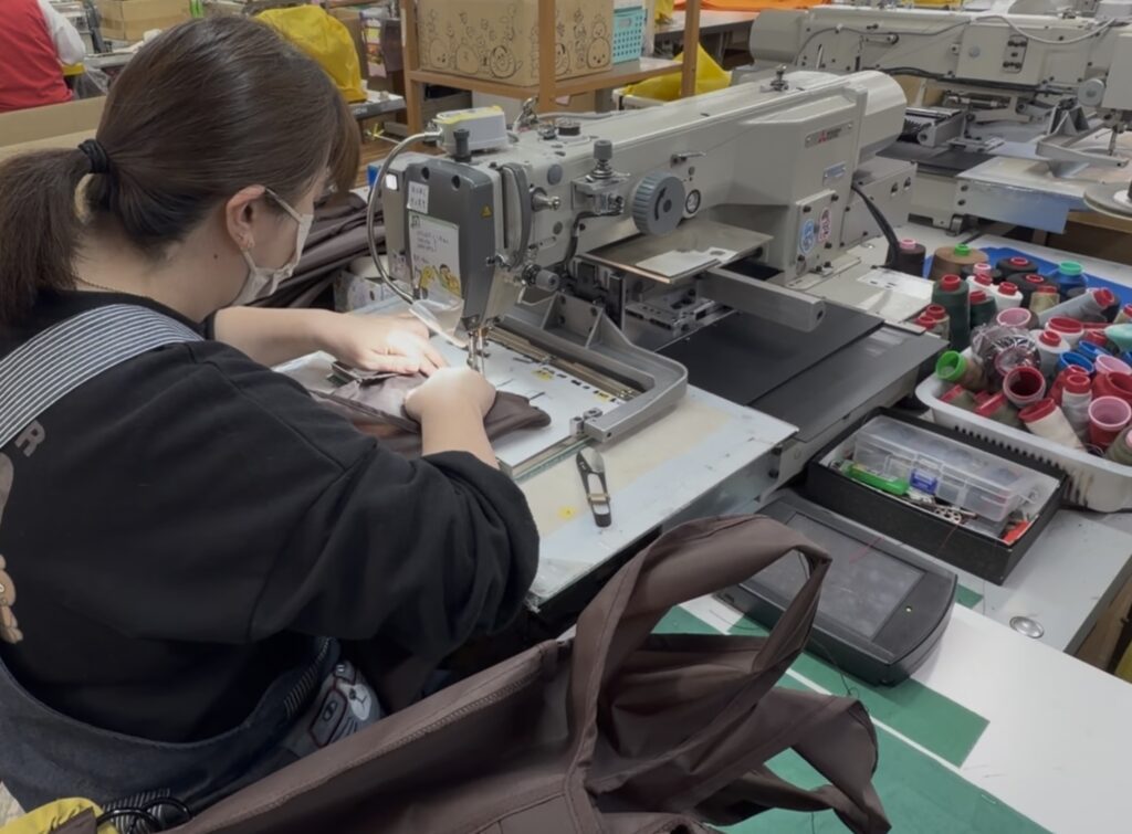 工業用バッグを縫製する職人と工業用ミシンの作業風景